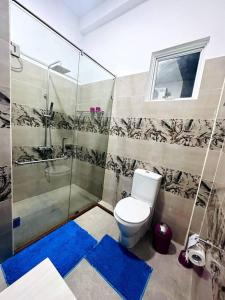 een badkamer met een toilet en een douche bij DreamScape Holiday Apartment Kalutara in Kalutara