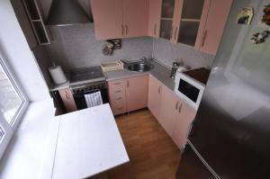 a small kitchen with pink cabinets and a refrigerator at Bastrakovi Apartment in Narva
