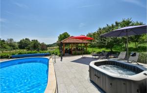 a swimming pool with an umbrella and a gazebo at Nice Home In Breznicki Hum With House A Panoramic View in Hrašćina