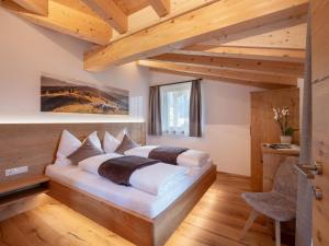 ein Schlafzimmer mit einem Bett in einem Zimmer mit Holzdecken in der Unterkunft Bauernhof Mühlbichl in Söll