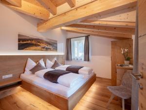 a bedroom with a bed in a room with wooden ceilings at Bauernhof Mühlbichl in Söll