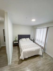 um quarto com uma cama grande num quarto branco em Miraflores House C&F em Lima