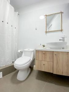 y baño con aseo blanco y lavamanos. en Miraflores House C&F, en Lima