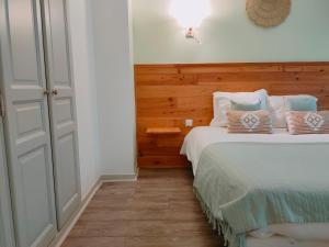 Schlafzimmer mit einem Bett mit blauen und weißen Kissen in der Unterkunft Le Royal Hôtel in Saint-Pol-sur-Ternoise