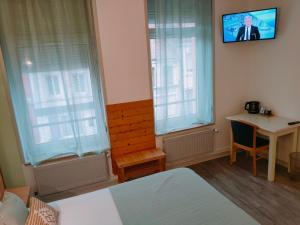 een kamer met een bed, een tafel en een televisie bij Le Royal Hôtel in Saint-Pol-sur-Ternoise