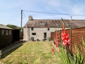 une maison blanche avec une clôture et une cour dans l'établissement Eiddwen, à Llanon