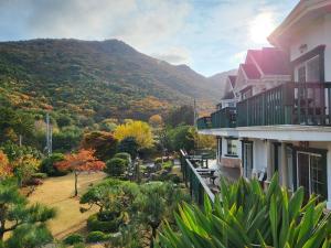 a view of a house with a mountain in the background at Didimdol Pension in Geoje 
