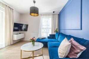 salon z niebieską kanapą i stołem w obiekcie Angielska Grobla Apartments w Gdańsku