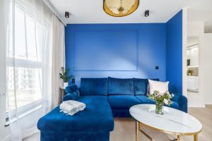 niebieski salon z niebieską kanapą i stołem w obiekcie Angielska Grobla Apartments w Gdańsku