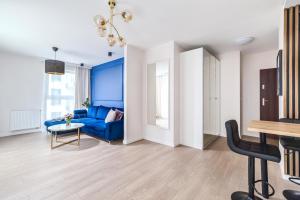 salon z niebieską kanapą i stołem w obiekcie Unique Apartments - Angielska Grobla w Gdańsku