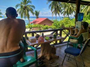 dos personas sentadas en una mesa en la playa en Hollow trees Mentawai HTS Surf camp Katiet front Hollow tree,Lance Right,Lance right,Bintang wave, en Katiet