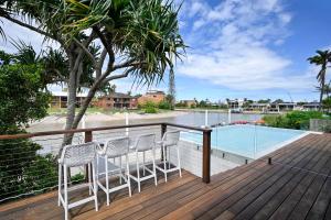 une terrasse avec deux chaises et une piscine dans l'établissement Stunning Mooloolaba Waterfront Home -10 guests ZB1, à Mooloolaba