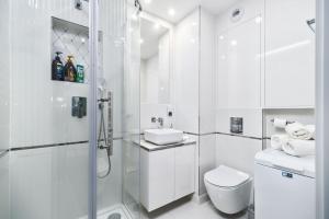 biała łazienka z prysznicem i toaletą w obiekcie Unique Apartments - Angielska Grobla w Gdańsku +33 zdjęcia