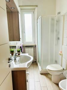 bagno con lavandino, servizi igienici e finestra di Appartamento Gufetto a Banchette