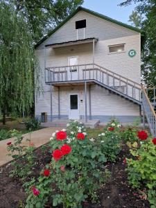 a house with a balcony and some red flowers at PARK HOTEL Uralsk in Oral