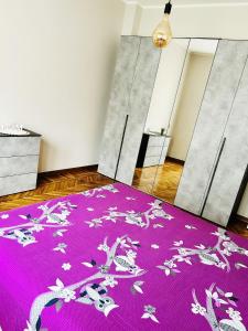 un tappeto viola con fiori sopra in una stanza di Appartamento Gufetto a Banchette