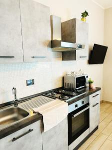 una cucina con lavandino e piano cottura forno superiore di Appartamento Gufetto a Banchette