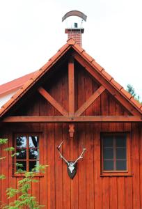 una cabaña de madera con un reloj al costado. en Hájenka hraběte Buquoye, en Kaplice