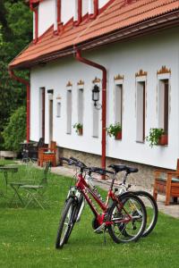 una bicicleta roja estacionada en el césped frente a un edificio en Hájenka hraběte Buquoye, en Kaplice