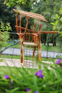 a wooden chair sitting in a swing in a garden at Hájenka hraběte Buquoye in Kaplice