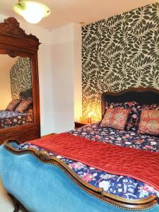 een slaapkamer met een bed en een spiegel bij Les capucines la souris des champs in Étival-Clairefontaine