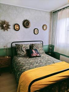 een slaapkamer met een bed en een aantal spiegels aan de muur bij Les capucines la souris des champs in Étival-Clairefontaine
