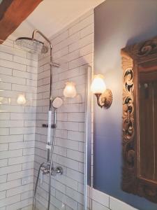 a shower in a bathroom with white tiles at Les capucines la souris des champs in Étival-Clairefontaine