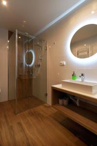 a bathroom with a shower and a sink and a mirror at APARTMÁNY ADAM in Jáchymov