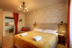 a bedroom with a large bed with two towels on it at APARTMÁNY ADAM in Jáchymov