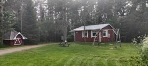 eine rote Hütte mit einem Picknicktisch im Hof in der Unterkunft Punainen tupa in Kalajoki