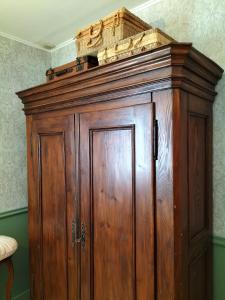 a wooden cabinet in the corner of a room at Les capucines la souris des champs in Étival-Clairefontaine
