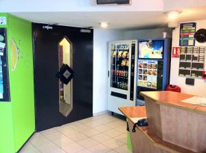 a restaurant with a counter and a drink refrigerator at Lemon Hotel - Tourcoing in Tourcoing