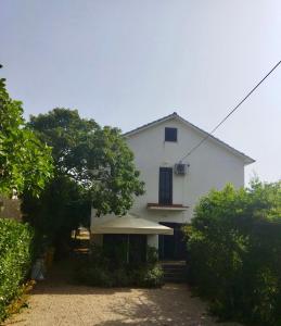 a white house with an umbrella in front of it at Holiday Home Bukovac in Klimno