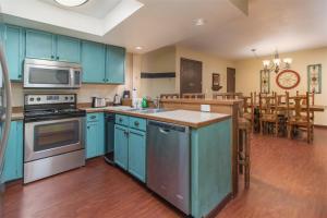 a kitchen with blue cabinets and a kitchen island with a microwave at Giant Steps 63 Ski In-out in Brian Head