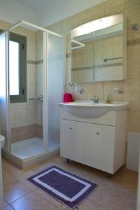 a bathroom with a white sink and a shower at Evangelia in Agia Effimia