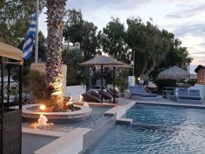 a swimming pool with a fire pit and a resort at Naxos Summerland resort in Kastraki Naxou