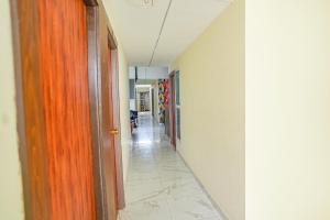 a hallway with a long corridor with a hallway at FabExpress Sanva, Pallikaranai in Chennai