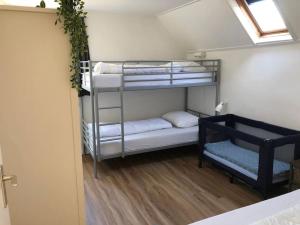a room with three bunk beds in a room at Grijpskerkseweg 3 voorhuis in Oostkapelle