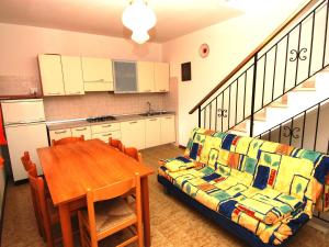 een woonkamer met een bank en een tafel en een keuken bij Sun drenched seaside holiday home close to Venice in Rosolina Mare