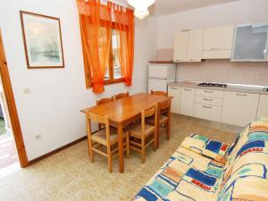 a kitchen and dining room with a table and a couch at Sun drenched seaside holiday home close to Venice in Rosolina Mare