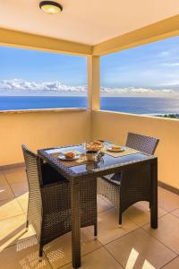 uma mesa e cadeiras numa varanda com vista para o oceano em Bleu Horizon em Saint-Leu