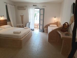 a hotel room with two beds and a balcony at Naxos Summerland resort in Kastraki Naxou