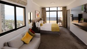 um quarto com uma cama, um sofá e uma janela grande em La Vida Suite em Beirute