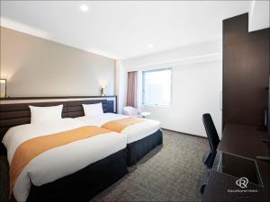 a hotel room with two beds and a window at Daiwa Roynet Hotel Osaka-Kitahama in Osaka