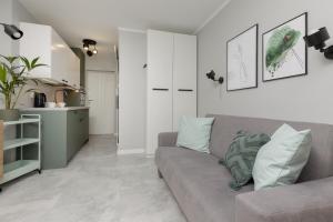 a living room with a couch and a kitchen at Cozy & Stylish Studio Ochota 1,5 km to Złote Tarasy by Renters in Warsaw