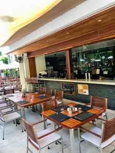 a restaurant with wooden tables and chairs and a bar at Beachfront 2 BR Luxury Condo Chava Surin in Surin Beach