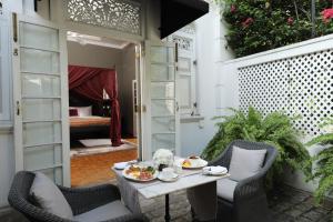 a patio with a table and chairs and a bedroom at Maniumpathy Hotel in Colombo