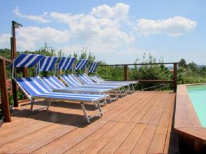 una fila de sillas azules sentadas en una terraza junto a una piscina en charming residence in the hills surrounding La Spezia, en Bolano