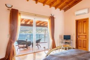 a bedroom with a bed and a sliding glass door at Villa Pasithea in Korfos