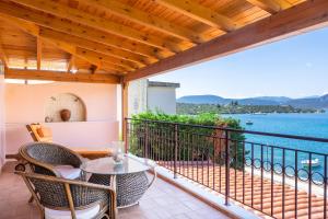 balcón con mesa, sillas y vistas al agua en Villa Pasithea, en Korfos
